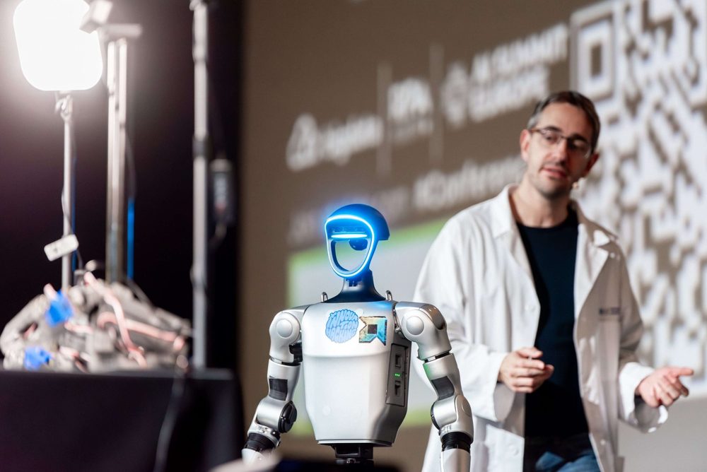 Speaker presenting a humanoid robot on the AI Summit Europe stage